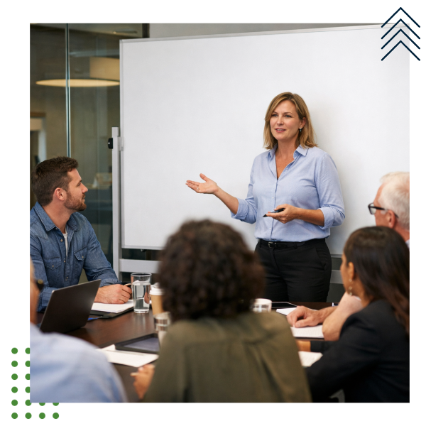 A person writing on a whiteboard in a business setting boardroom drafting an outline  People are sitting at the boardroom table in a collaborative man-Mar-26-2026-07-48-00-5405-PM-1-1